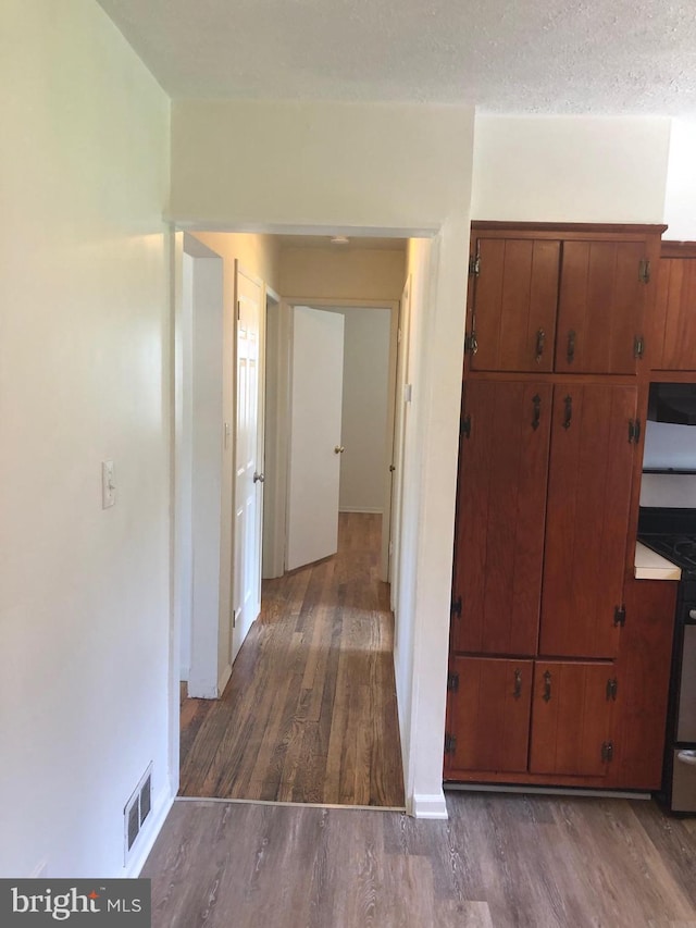 hall featuring a textured ceiling and dark hardwood / wood-style floors