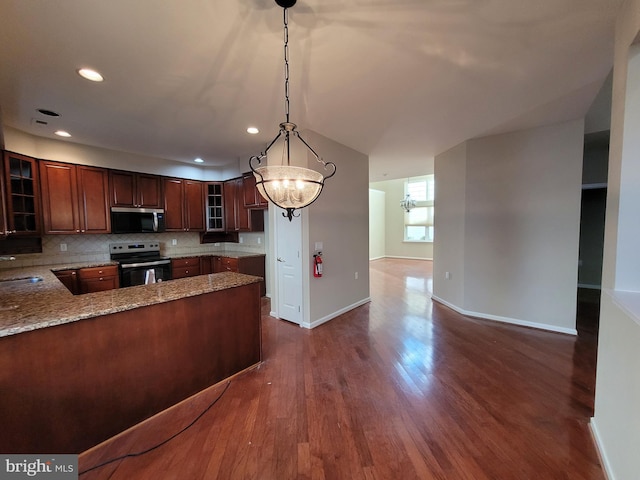 kitchen with kitchen peninsula, appliances with stainless steel finishes, backsplash, an inviting chandelier, and hanging light fixtures