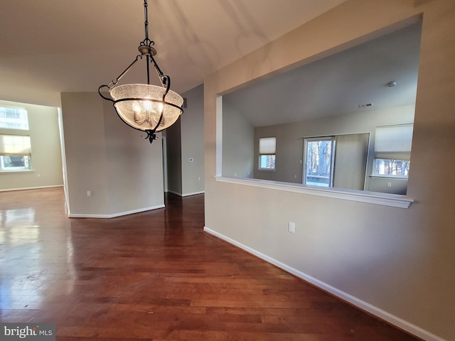 unfurnished dining area with a chandelier and hardwood / wood-style floors