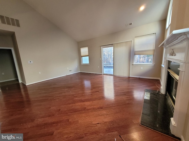 unfurnished living room featuring dark hardwood / wood-style flooring and lofted ceiling