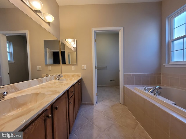 bathroom with tile patterned floors, tiled bath, and vanity