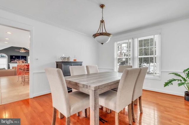 dining space featuring crown molding, ceiling fan, and light wood-type flooring