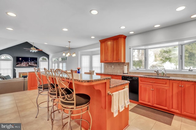 kitchen featuring sink, a breakfast bar area, black dishwasher, a kitchen island, and lofted ceiling