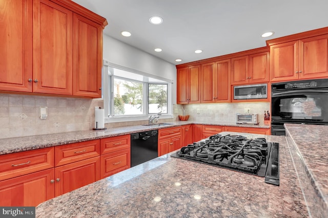 kitchen with sink, backsplash, stone counters, and black appliances