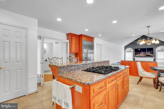 kitchen with black gas cooktop, stainless steel built in fridge, a chandelier, a center island, and hanging light fixtures