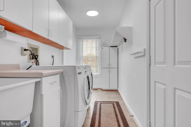 laundry area with separate washer and dryer, sink, light tile patterned floors, and cabinets