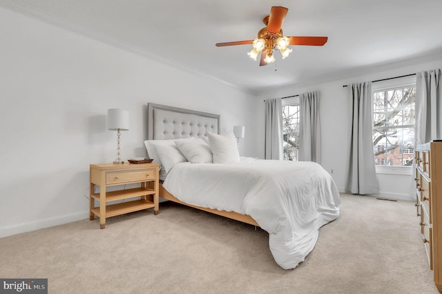 carpeted bedroom featuring ceiling fan and ornamental molding