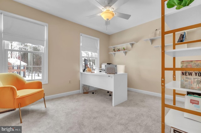 carpeted office space featuring ceiling fan