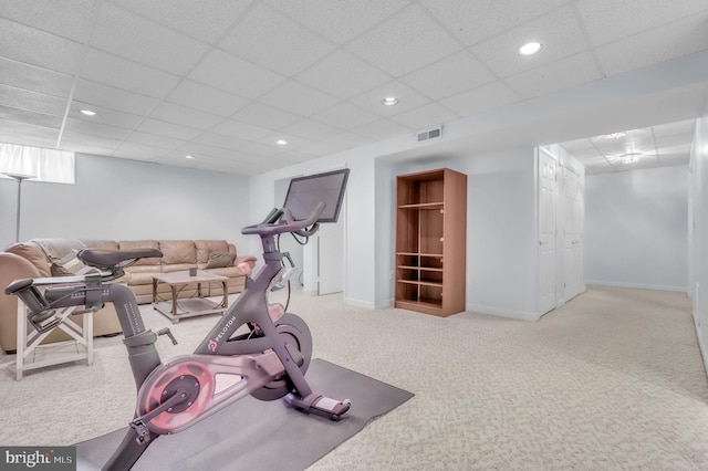 exercise area featuring carpet flooring and a drop ceiling