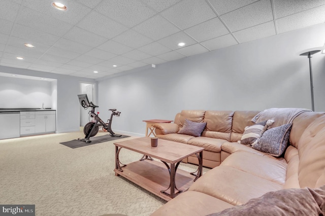 carpeted living room with a paneled ceiling