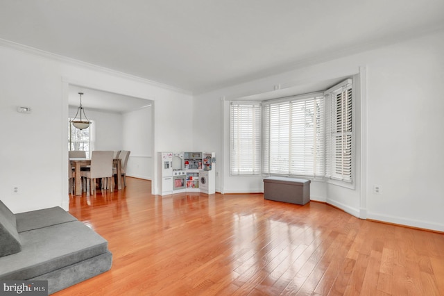 interior space with plenty of natural light, ornamental molding, and hardwood / wood-style flooring