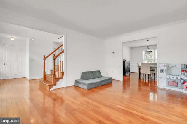 sitting room with hardwood / wood-style floors and crown molding