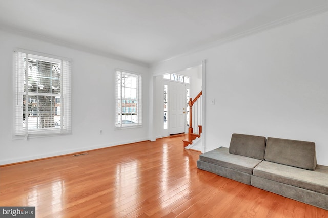 living room featuring light wood-type flooring and ornamental molding