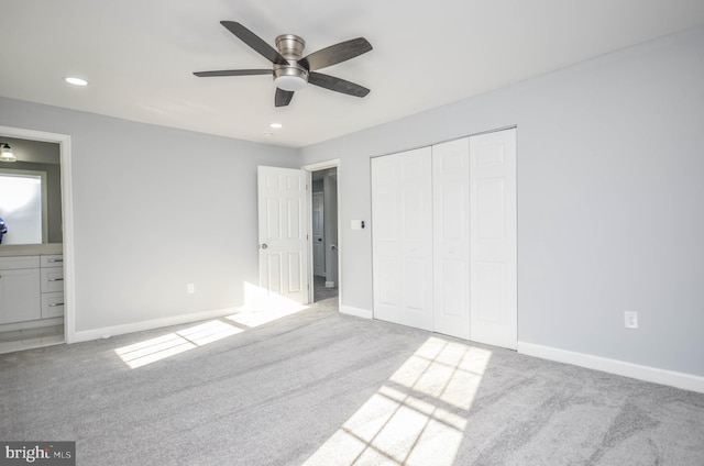 unfurnished bedroom with connected bathroom, ceiling fan, a closet, and carpet floors