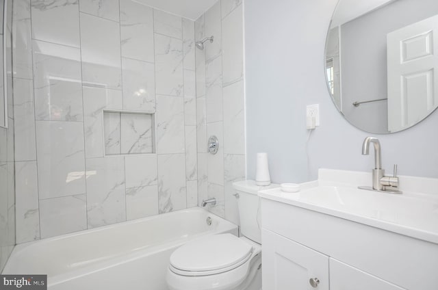 full bathroom featuring tiled shower / bath combo, toilet, and vanity