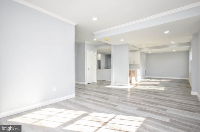 unfurnished living room with crown molding and light hardwood / wood-style flooring