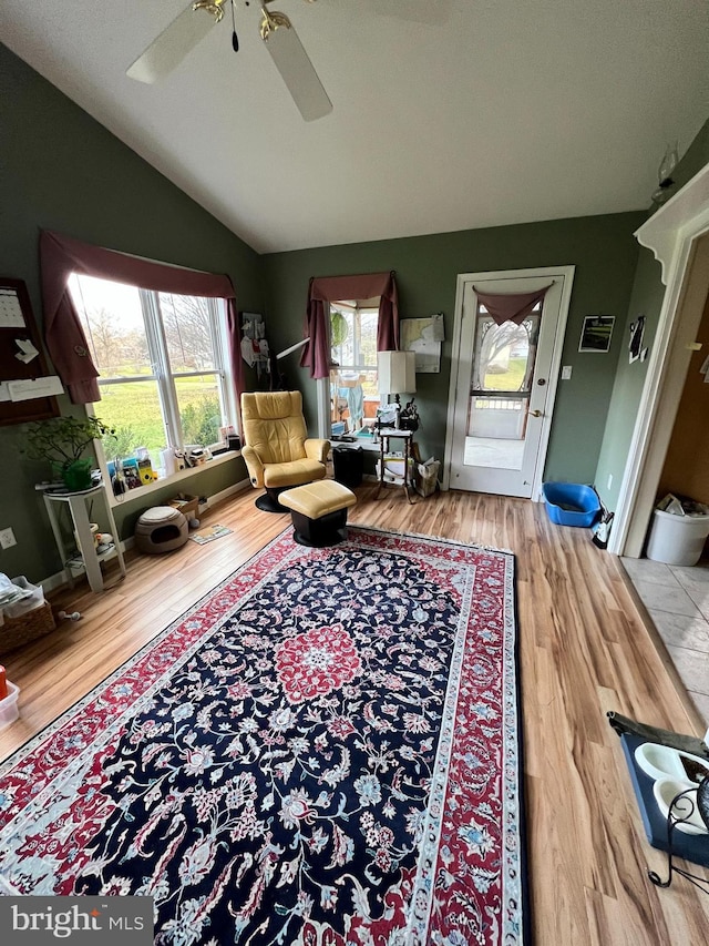 living room with hardwood / wood-style flooring, ceiling fan, and lofted ceiling