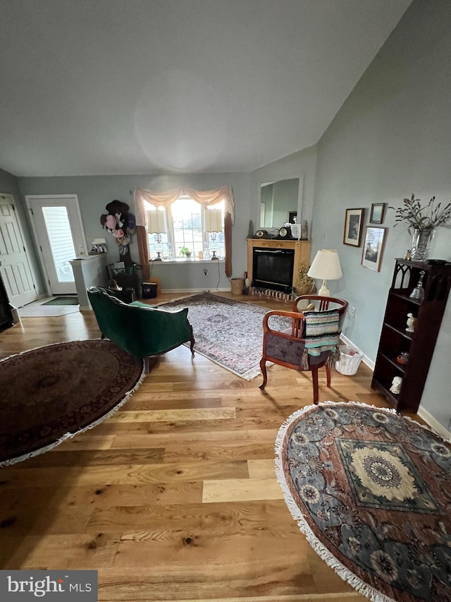 living room with wood-type flooring and vaulted ceiling