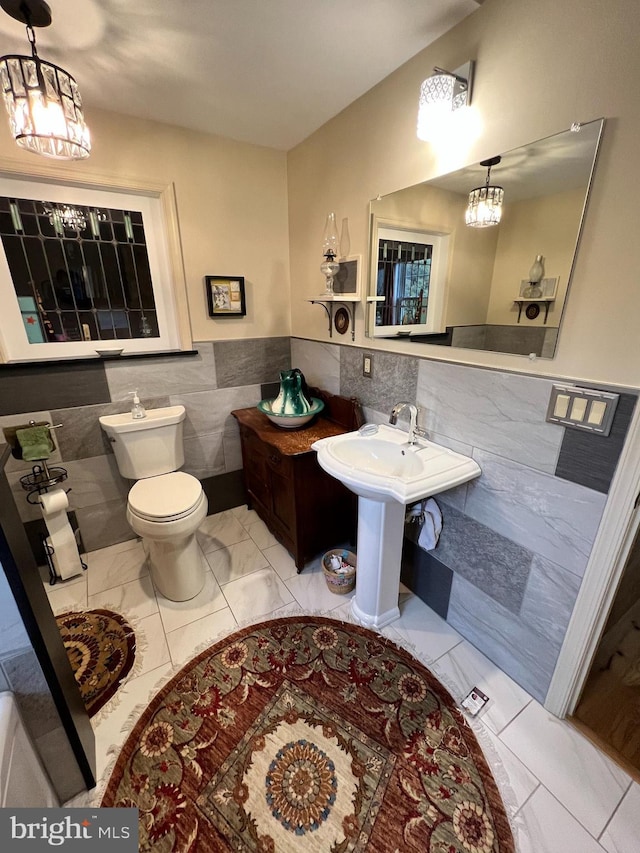 bathroom featuring tile walls and toilet