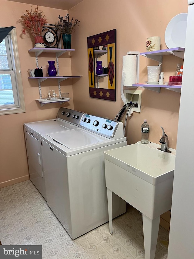 clothes washing area featuring sink and washing machine and clothes dryer