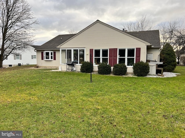 rear view of property with a lawn