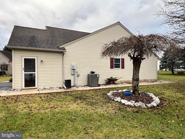 exterior space with central air condition unit and a lawn