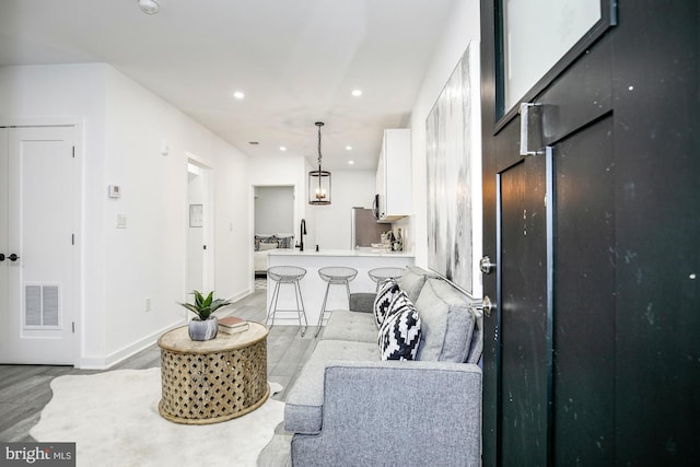 living room featuring light wood-type flooring and sink