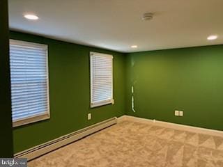 unfurnished room with carpet flooring and a baseboard radiator