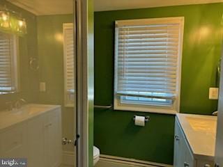 bathroom with vanity, a healthy amount of sunlight, and toilet