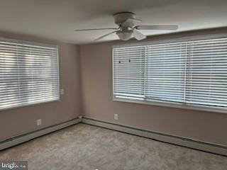 unfurnished room with ceiling fan and a baseboard heating unit