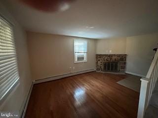 unfurnished living room featuring dark hardwood / wood-style flooring, a fireplace, and a baseboard radiator