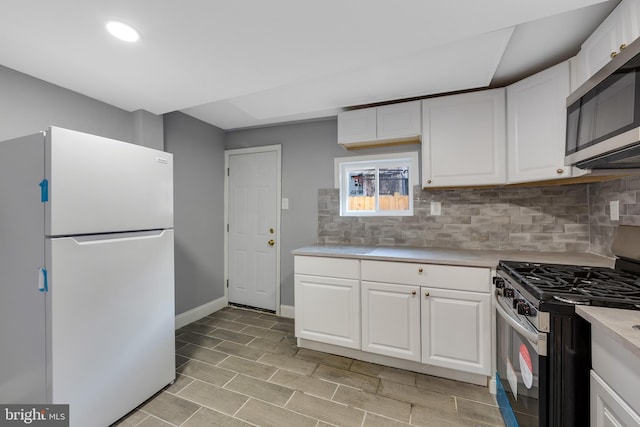 kitchen featuring stainless steel appliances, white cabinetry, and tasteful backsplash