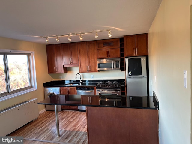 kitchen featuring light wood-type flooring, sink, and appliances with stainless steel finishes