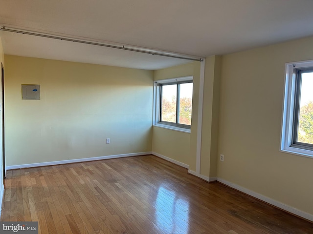 unfurnished room with electric panel and light wood-type flooring