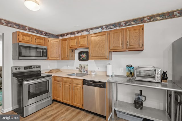 kitchen featuring sink, stainless steel appliances, and light hardwood / wood-style flooring