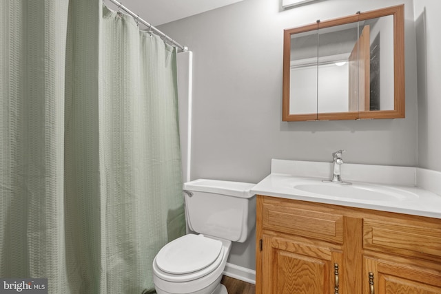 bathroom with a shower with shower curtain, vanity, and toilet