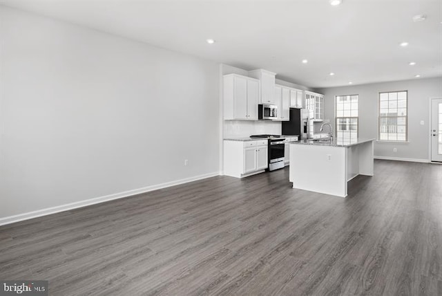 kitchen with white cabinetry, a kitchen island with sink, dark wood-type flooring, and appliances with stainless steel finishes