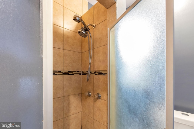 bathroom featuring toilet and tiled shower