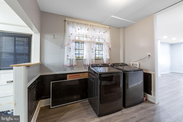 laundry room with washer and dryer and light hardwood / wood-style flooring