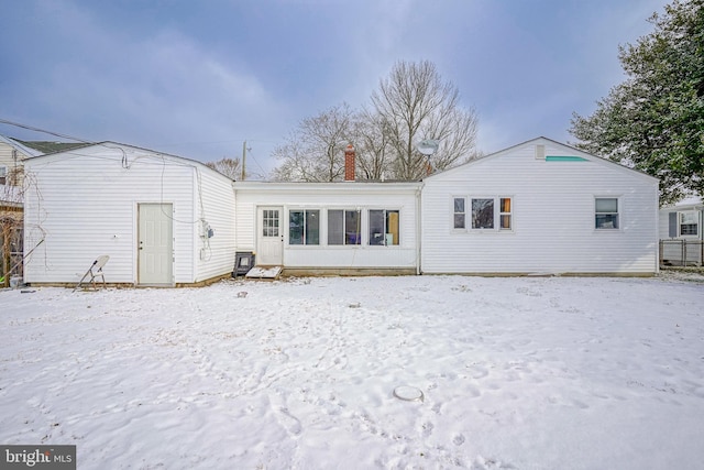 view of snow covered back of property