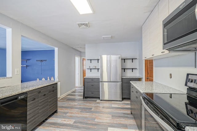 kitchen featuring stainless steel appliances and light stone counters