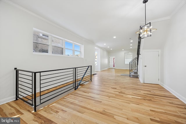 interior space with an inviting chandelier, ornamental molding, and hardwood / wood-style floors