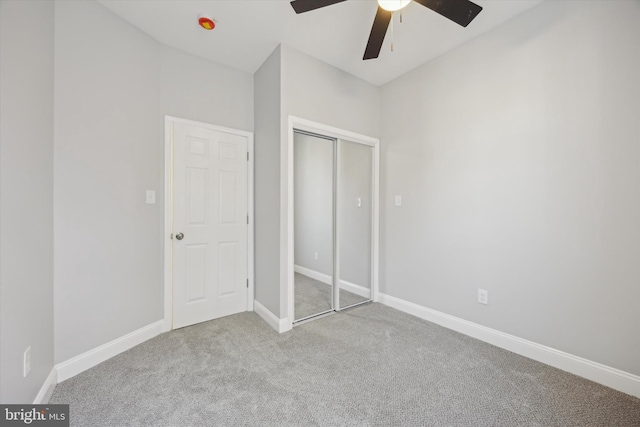 unfurnished bedroom featuring light carpet, a closet, and ceiling fan