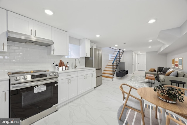 kitchen with stainless steel appliances, sink, white cabinets, and decorative backsplash