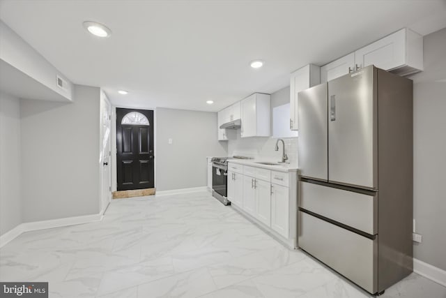 kitchen with tasteful backsplash, white cabinetry, appliances with stainless steel finishes, and sink