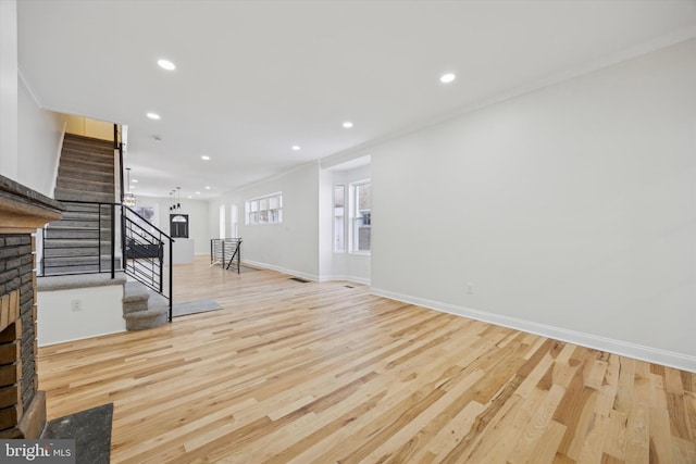 interior space with ornamental molding, a fireplace, and light hardwood / wood-style floors