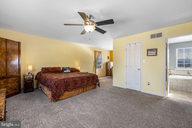 carpeted bedroom with ceiling fan and ensuite bath