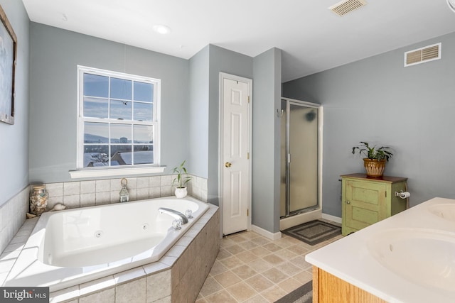 bathroom with vanity and shower with separate bathtub