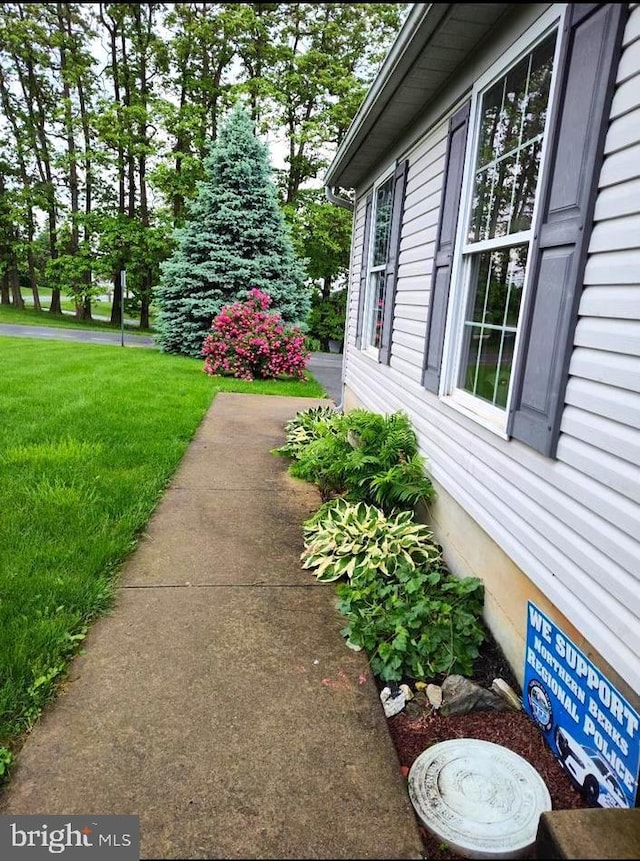 view of side of home with a lawn