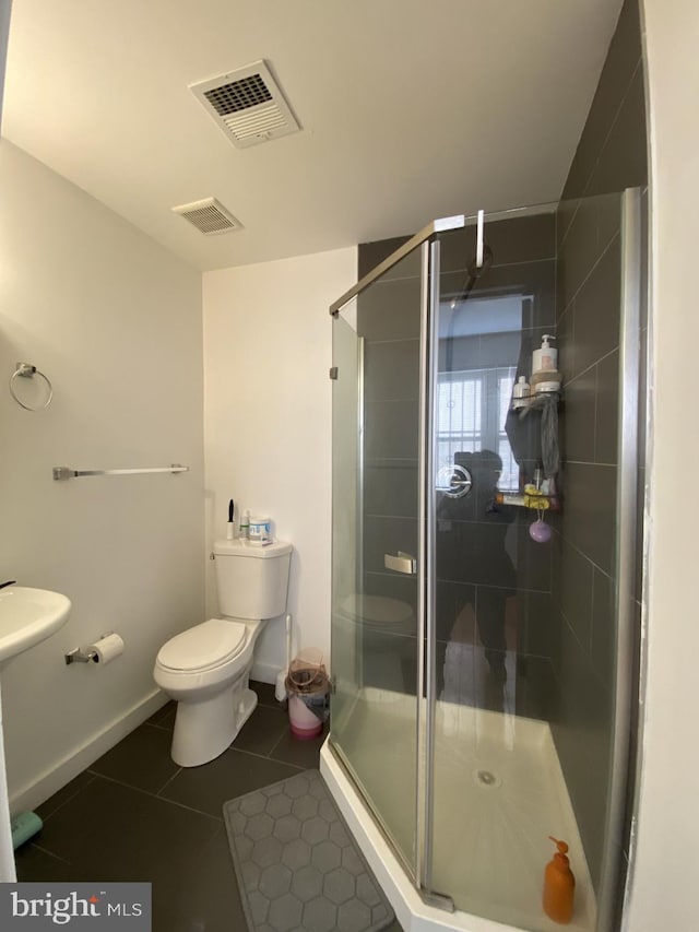 bathroom with toilet, tile patterned floors, a shower with shower door, and sink